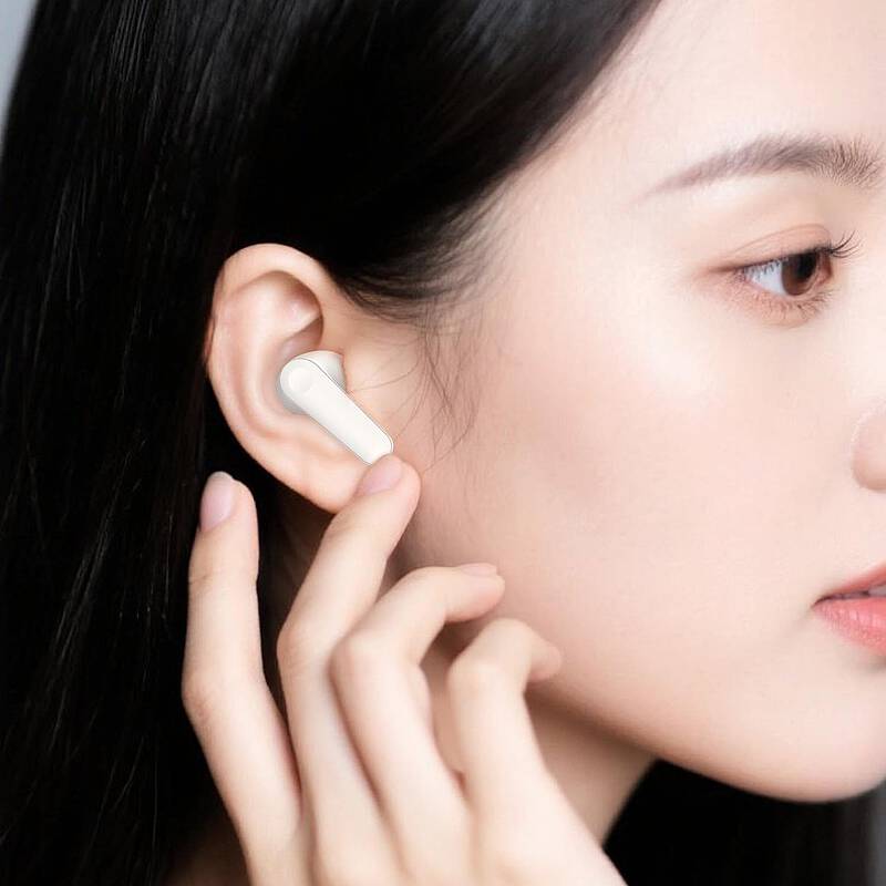 Person wearing a white wireless earbud in their ear
